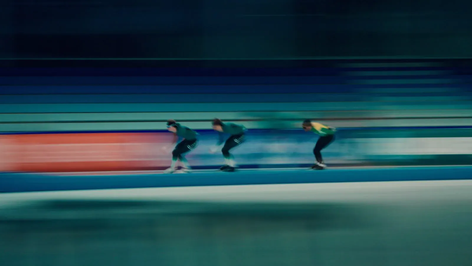 Drie schaatsers in volle vaart op de baan